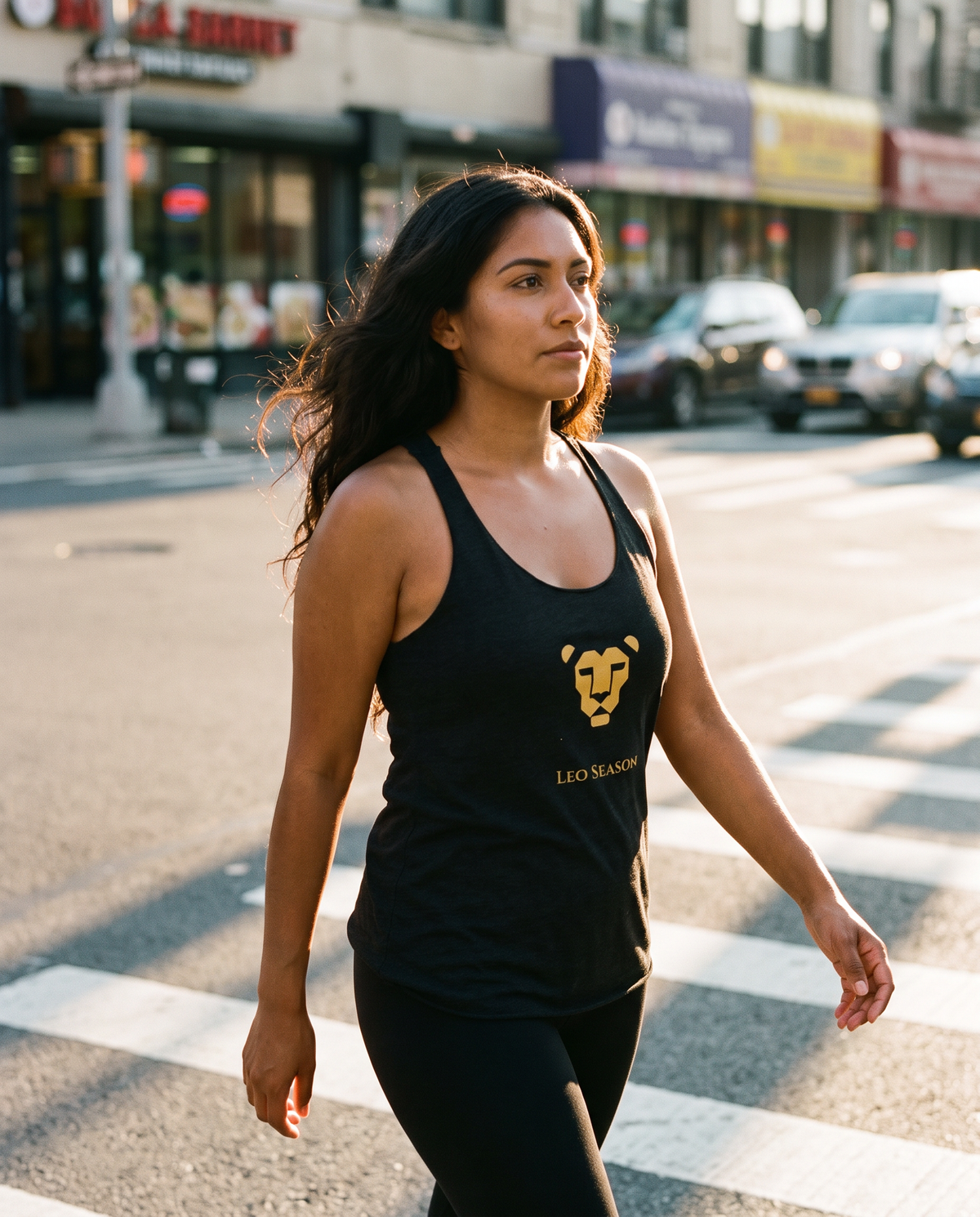 Woman walking in the Lioness Fire Tank in Vintage Black, golden hour city light