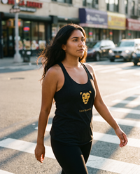 Woman walking in the Lioness Fire Tank in Vintage Black, golden hour city light