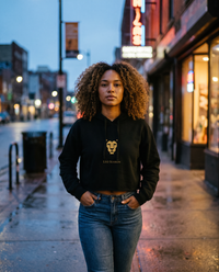 Woman walking in the Lioness Fire Crop Hoodie in Black, evening city light
