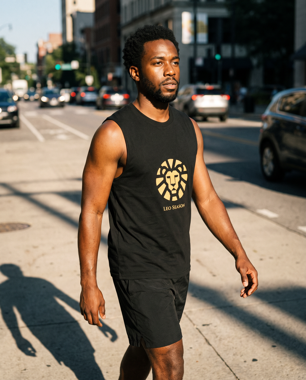 Man wearing the Lion Fire Muscle Tank in Black crossing a sunlit city street