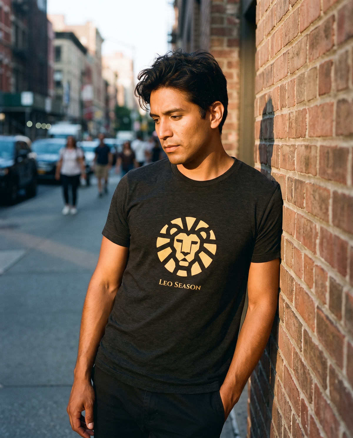 Man wearing the Lion Fire Tee in Charcoal Black on a sunlit city sidewalk