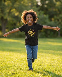 Child wearing the Cub Fire Tee in Black running in a sunny park